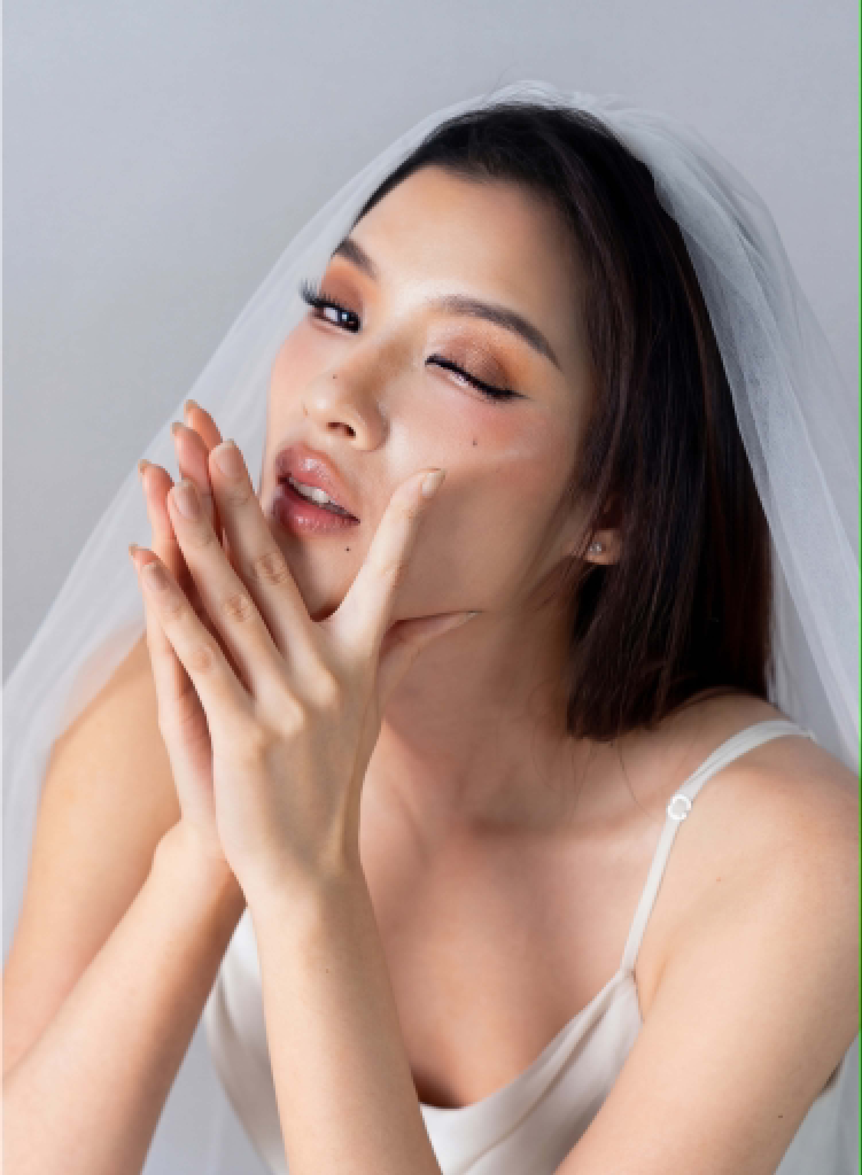 Bridal — orange eye, veil, hands framing face